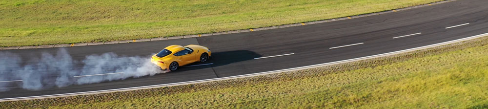 Un’auto sportiva gialla su un circuito di guida sull’asciutto durante un test di Tyre Reviews su pneumatici ultra high performance